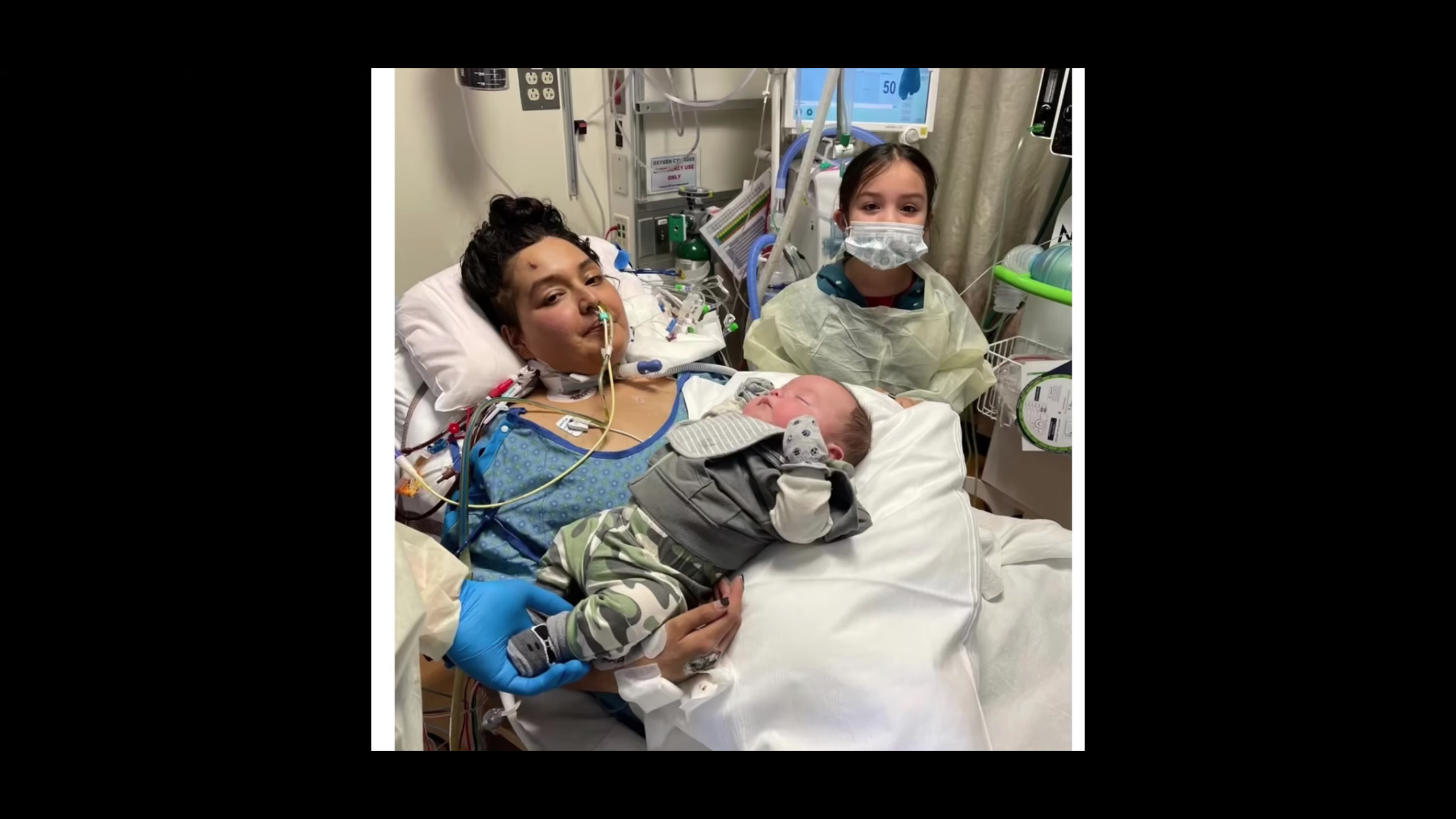 Mother holding newborn child while recovering from COVID-19